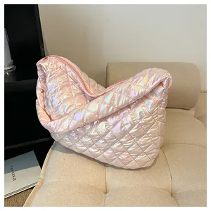 Nahaufnahme einer rosa schillernden, gesteppten Puffy-Hobo-Tasche auf dem Sofa