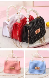 Selección de minibolsos de gelatina de colores con asas de perlas y cadenas doradas.