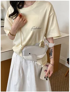 Modell mit einer süßen silbernen Umhängetasche in Walform aus Leder und einer Goldkette
