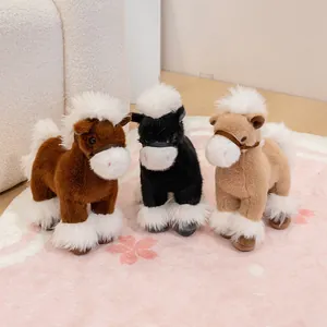 Detail shot of three realistic horse plush toys in brown, black, and beige colors