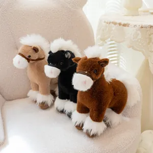 Three realistic plush horse toys in brown and black colors on a cozy white armchair.