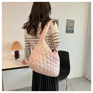 Rosa irisierende gesteppte Puffer-Tasche an einem Modell in stilvoller Inneneinrichtung