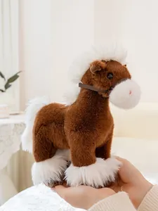 Soft brown and white plush horse toy held in hand to show size and texture details.