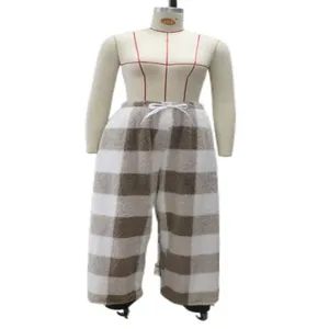 Detail view of brown plaid fleece pants with a cozy fuzzy texture and white drawstring.