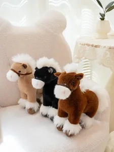 Detailed view of three soft plush horse toys in brown black and tan on a cozy white chair