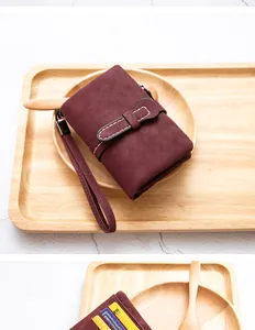 Close-up of burgundy PU leather short foldable wallet with wristlet and card slots