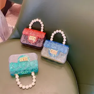 Dettaglio di mini borse in gelatina di PVC con manici di perle e trama trapuntata