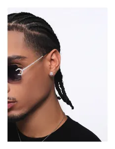 Macro view of iced out square stud earring worn by model, showing sparkling hip hop style details