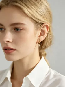 Detail of sterling silver hoop earrings with marquise cubic zirconia drop on model