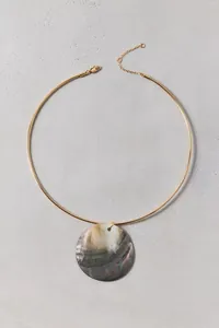 Macro detail of natural iridescent shell pendant necklace with gold choker for summer beach.