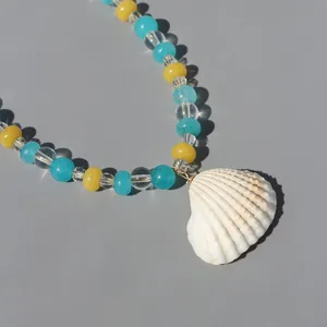 Detailed macro shot of a white shell pendant and colorful natural stone beads necklace.