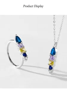 Close-up detail of 925 sterling silver ring and necklace with colorful geometric gemstones.