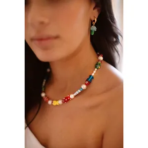 Vue détaillée d'un collier de perles de poisson en verre coloré fait main sur un modèle