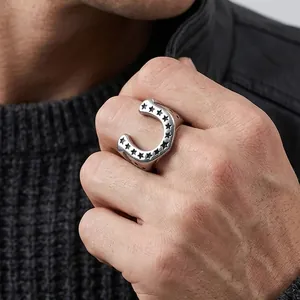 Detail view of men's stainless steel horseshoe ring with engraved pentagram stars