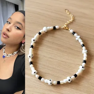 Détail d'un collier en perles d'eau douce fait main avec perles champignons en verre noir et blanc