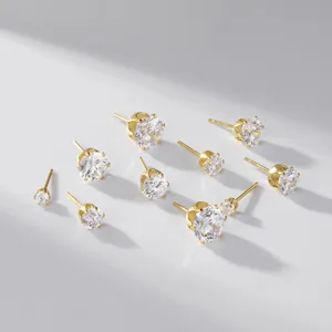 Close-up detail of classic 925 silver gold-plated six-prong stud earrings in various sizes