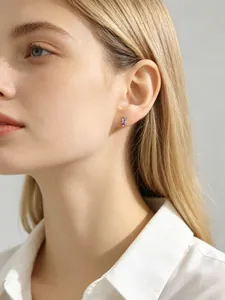 Close-up view of elegant purple rectangular zircon silver stud earrings on a model