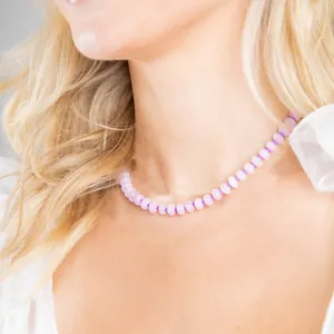 Vista detallada de un collar de cuentas de ábaco de piedra natural rosa en una modelo