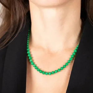 Primer plano de un collar de cuentas de piedra natural verde en el cuello de modelo