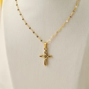 Close-up of golden hollow cross pendant on a flat link chain necklace for women