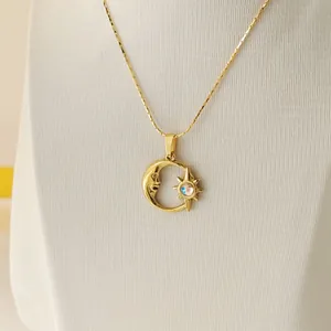 Close-up of gold moon and star pendant with iridescent stone on a textured background