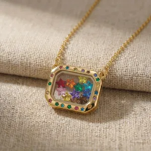 Close-up detail of a gold square locket necklace filled with colorful star-shaped charms