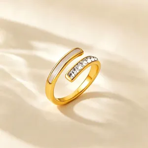 Gros plan d'une bague dorée ouverte ornée de nacre blanche et de zircons cubiques brillants