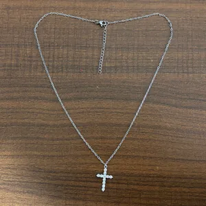 Detail view of silver-toned cross pendant necklace with sparkling cubic zirconia stones