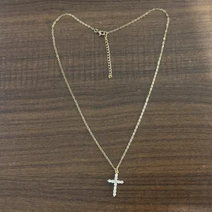 Detailed view of a gold stainless steel necklace with a sparkling cubic zirconia cross