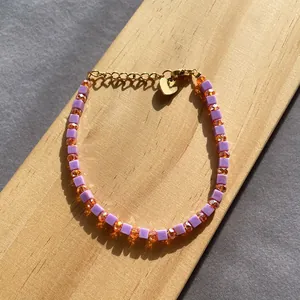 Vue détaillée d'un bracelet de perles colorées dopamine avec breloque cœur doré