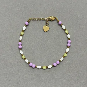Détail d'un bracelet en pierres naturelles colorées avec un pendentif en cœur doré