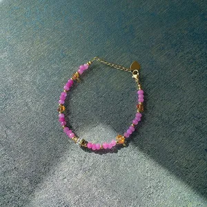 Détail d'un bracelet de perles colorées de style dopamine avec breloque cœur et pierres