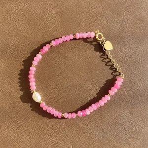 Bracelet en pierres roses avec perle baroque et breloque cœur doré.