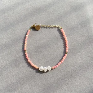Vue détaillée du bracelet en pierre naturelle rose avec perles et breloque cœur doré