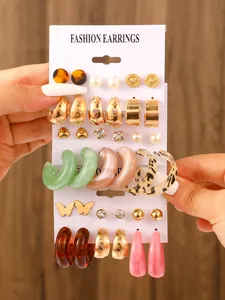 Detailed view of mixed resin and gold-tone earring set on a white display card.