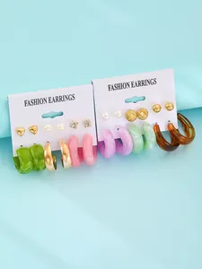 Close-up detail of colorful resin earring set including 6 pairs of studs and chunky hoops