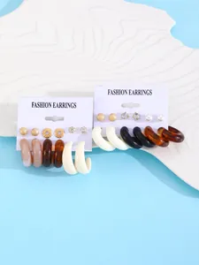 Close-up detail of 6-pair resin earring set featuring colorful hoops and studs on white display cards