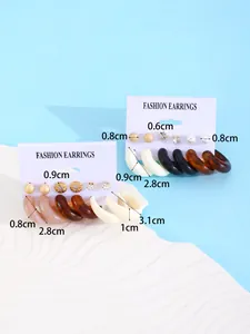 Detailed view of multi-color resin hoop and stud earring set with size measurements