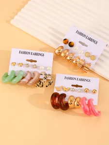 Detail showing colorful resin hoop earrings and mixed stud earring set on display cards.