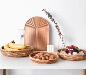 Juego de bandejas redondas de ratán para frutas y frutos secos en hogar cálido.