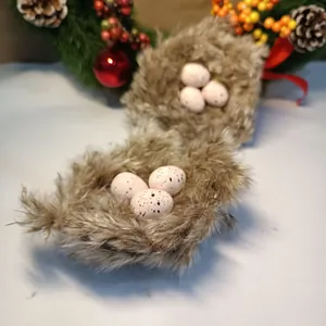 Close-up of decorative bird nests with speckled eggs and Christmas wreath accents