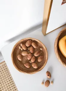 Primer plano de una bandeja redonda de ratán tejida a mano con nueces en entorno acogedor
