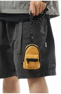 Vista detallada de la mini bolsa amarilla en forma de mochila para monedas y audífonos