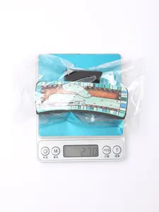 Pince à cheveux motif cactus western pesant 27,0g sur une balance dans un sac plastique.