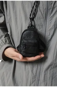 Vista detallada de una mini bolsa de cuello negra para monedas y auriculares