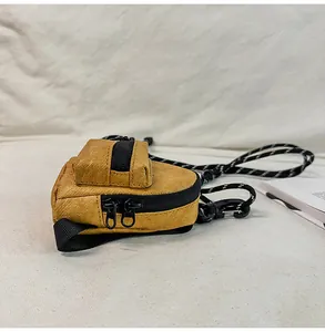 Vista detallada del mini bolso amarillo de cuello con tela texturizada única y doble cremallera