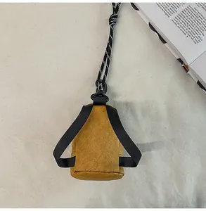 Primer plano de mini bolso de cuello con forma de mochila en tela marrón texturizada