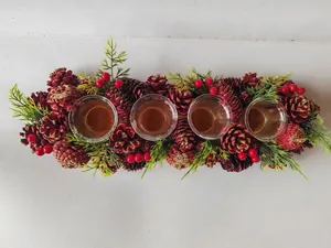 Top-down view of Christmas candle holder with red pine cones and four glass cups