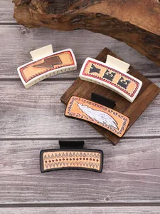Vue détaillée de pinces à cheveux style western avec motifs de plumes en cuir