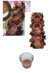 Close-up view of a festive Christmas wreath candle holder with pine cones and roses.